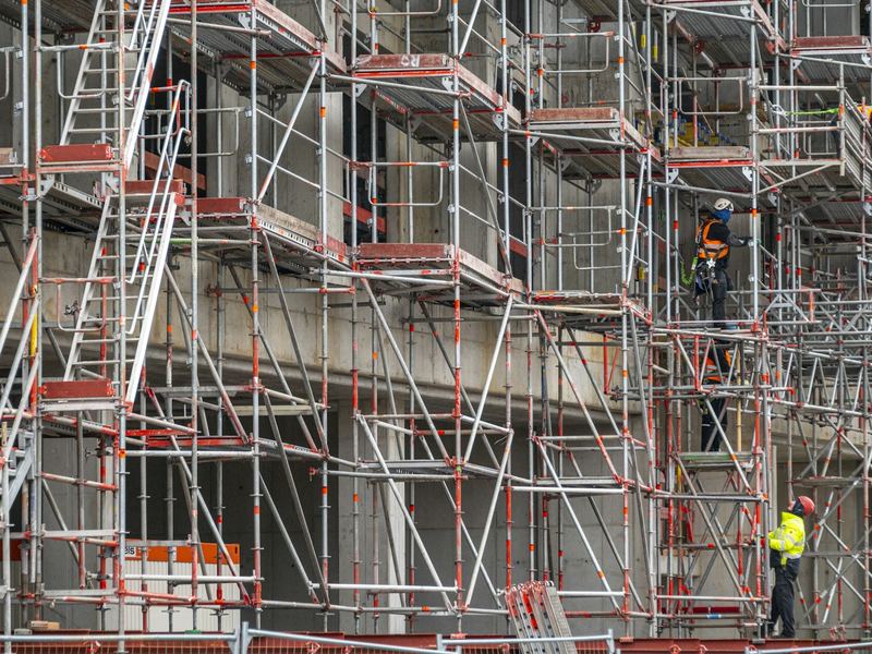 Operai su un ponteggio davanti alla facciata di un palazzo